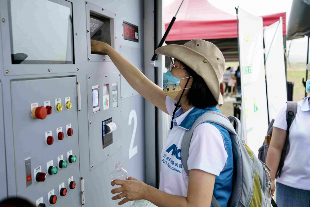志工們將拾起的寶特瓶投入「好歸塑專車」，讓廢棄塑料空瓶可以直接粉碎、縮小體積，未來將可再製成購物袋、寶特衣、悠遊卡等生活用品